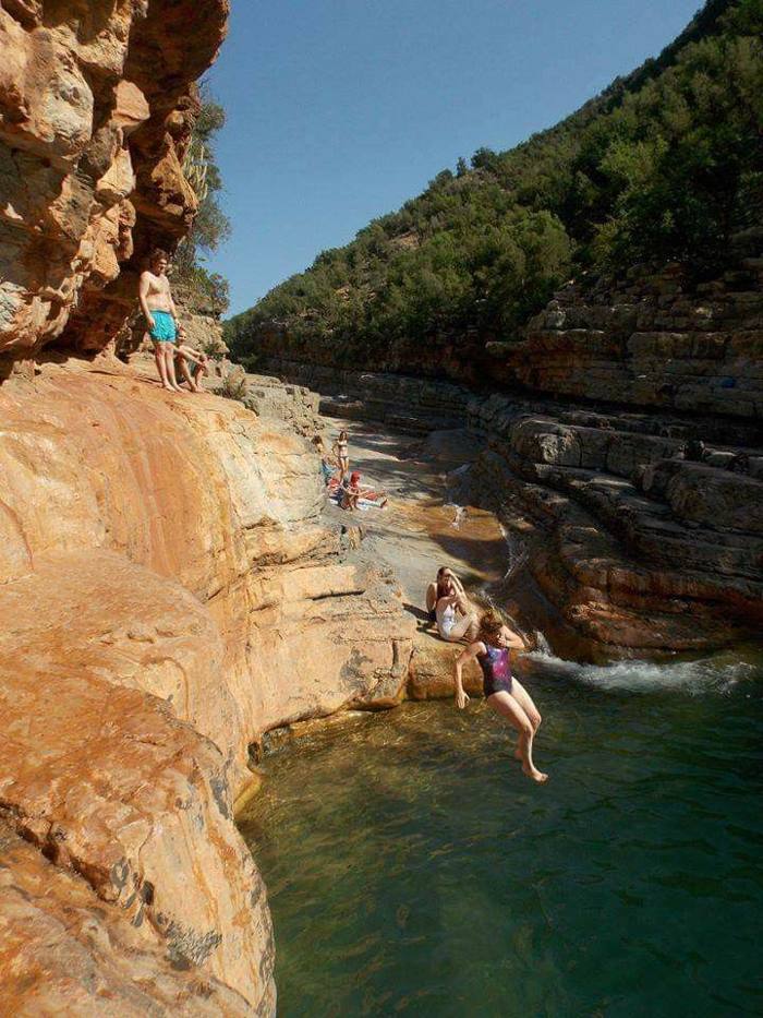 Person jumping from the rock into the pool
